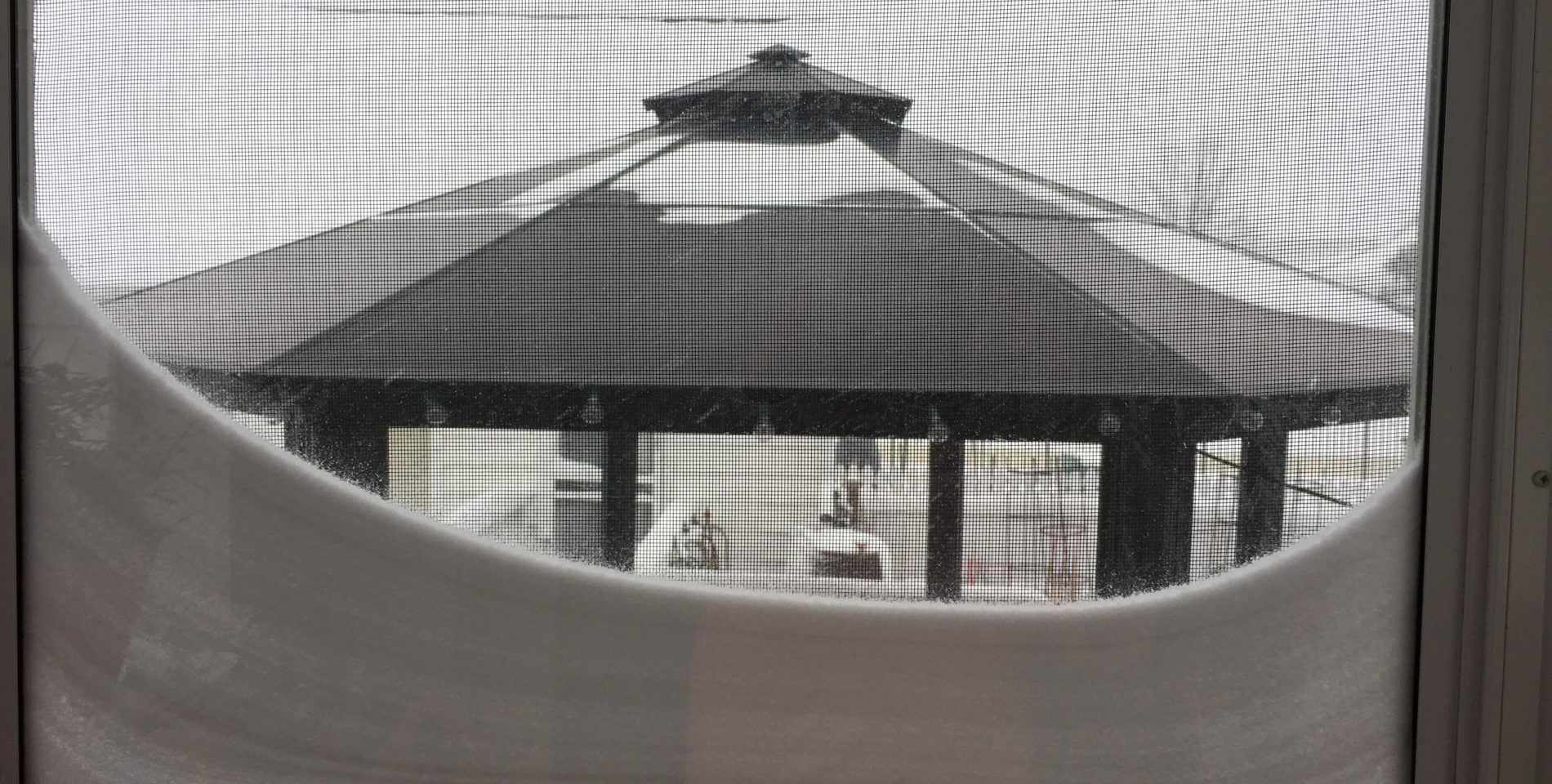Snow lining the windowsill at the Inn with a white snow covered gazebo in the background.