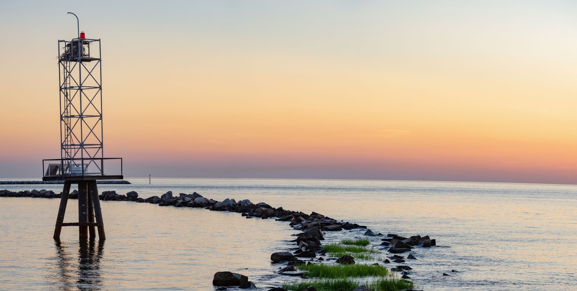 view of the ocean with orange and pink skies at sunrise at cape charles