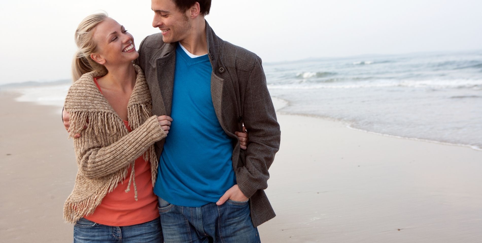 couple walking close to each other on the beach