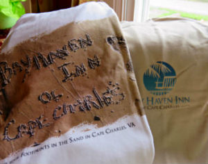 A white t-shirt with a sandy beach and the text: Bay Haven Inn of Cape Charles.