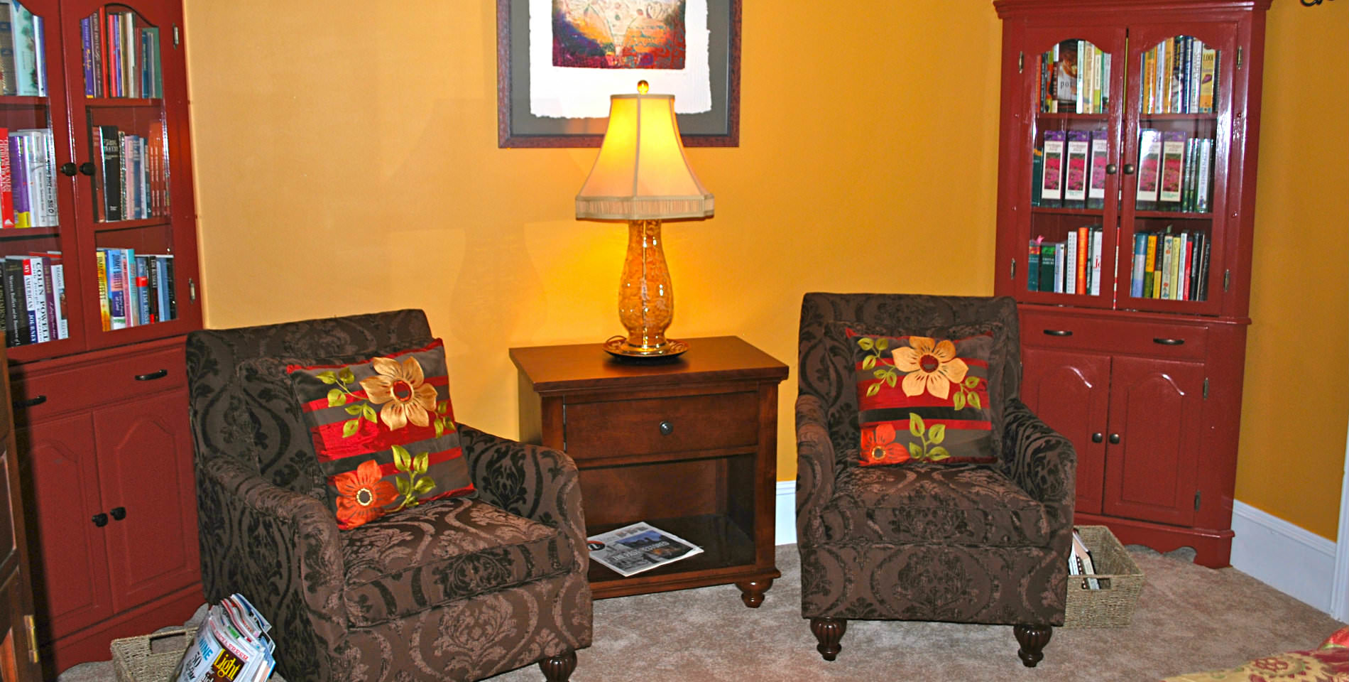 Two black and gray patterned chairs near two tall wooden bookcases in the Virginia Wilson room. 