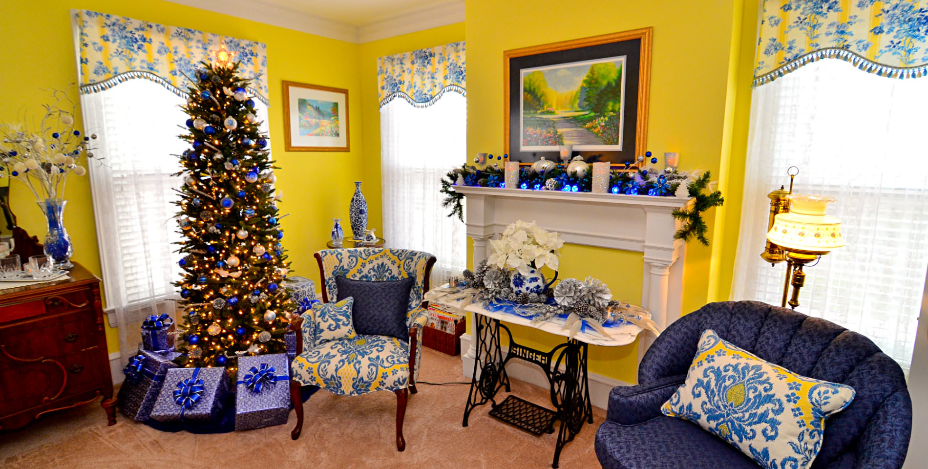 A Christmas tree in the sitting area with festive blue presents and decorations.