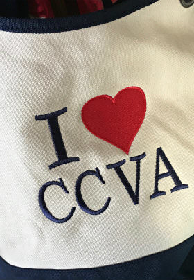 A white bib with navy blue trim and the text: I heart CCVA.